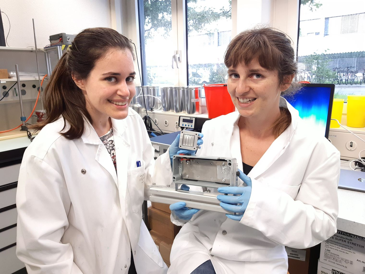 Victoria Manzi and Muriel Siegwart from PSI in Switzerland holding the test cell used in the experiment. Credit: Natasa Diklic, PSI